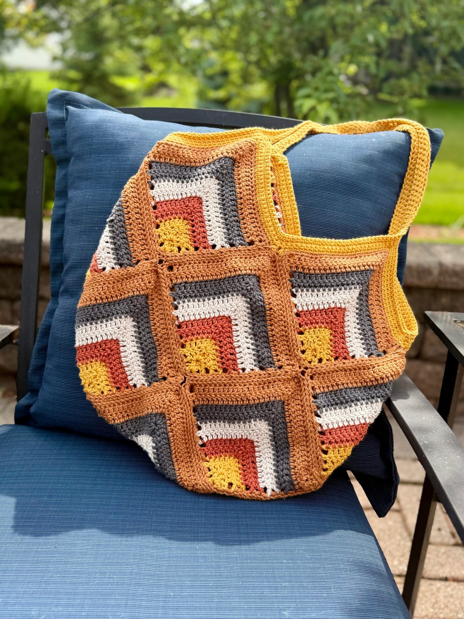 farmer's market cotton crochet tote in earthy tones hanging on chair