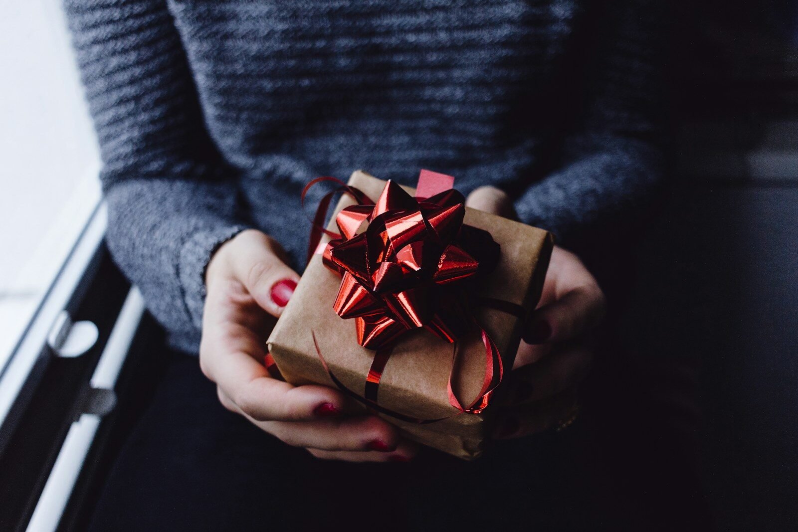 person holding present box with crochet gift